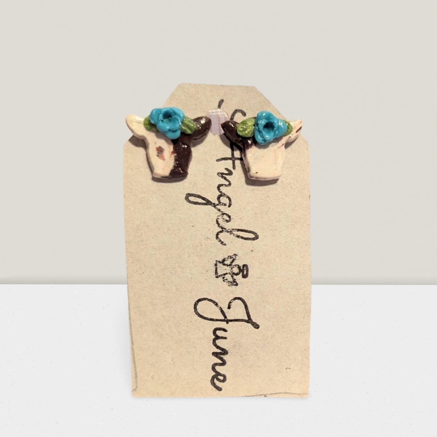 Brown spotted cow with blue flower studs